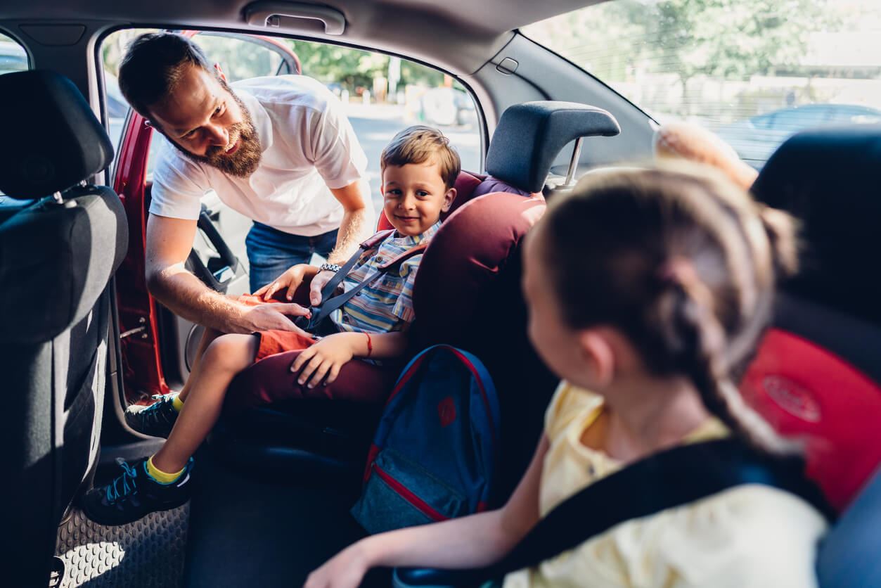Dad buckling kids into car